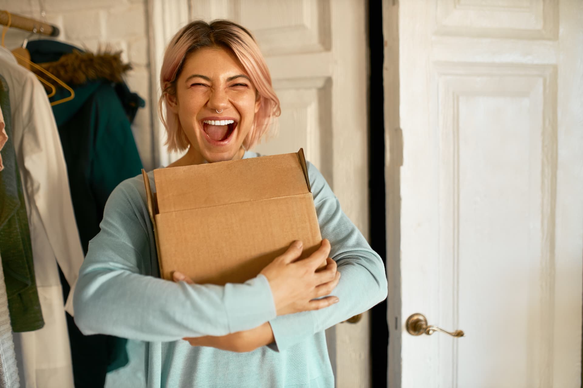 Cliente sorrindo ao receber uma encomenda em casa