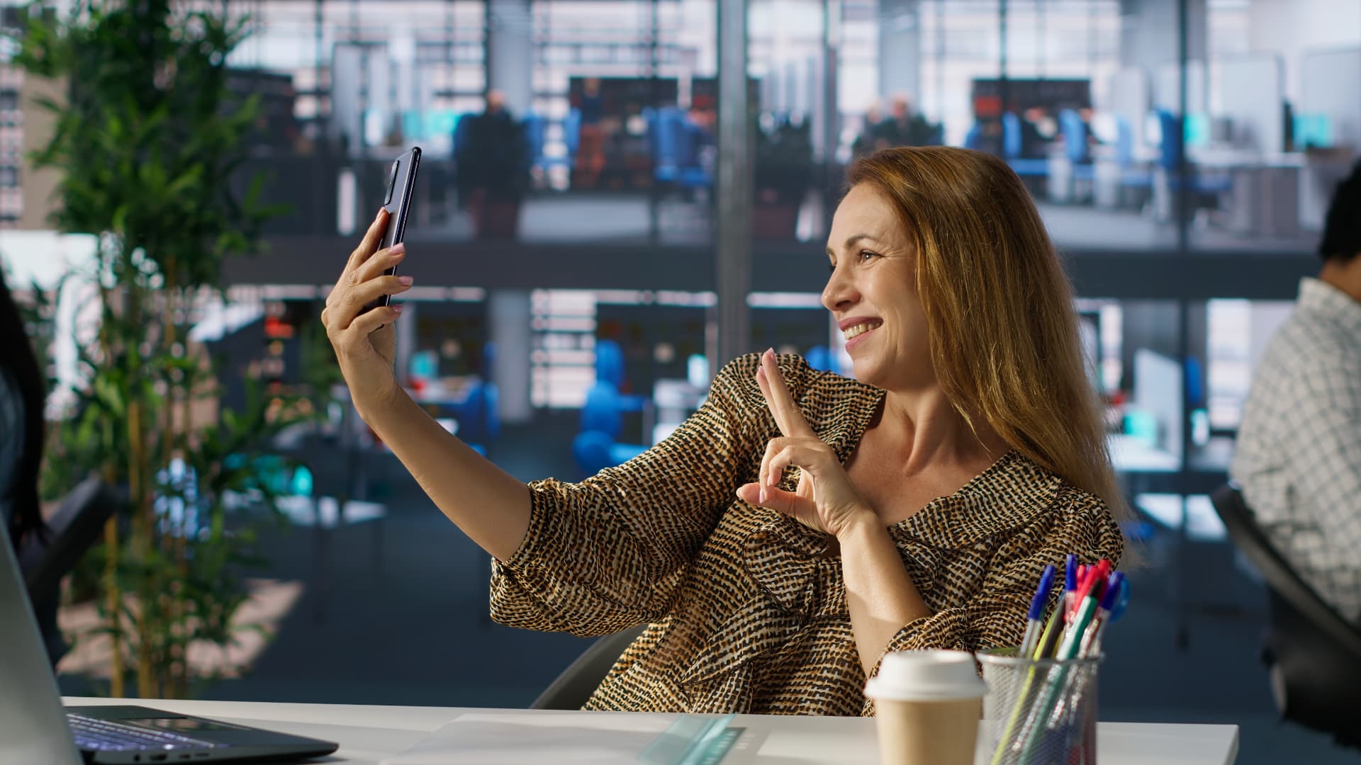 Mulher usando o celular no escritório