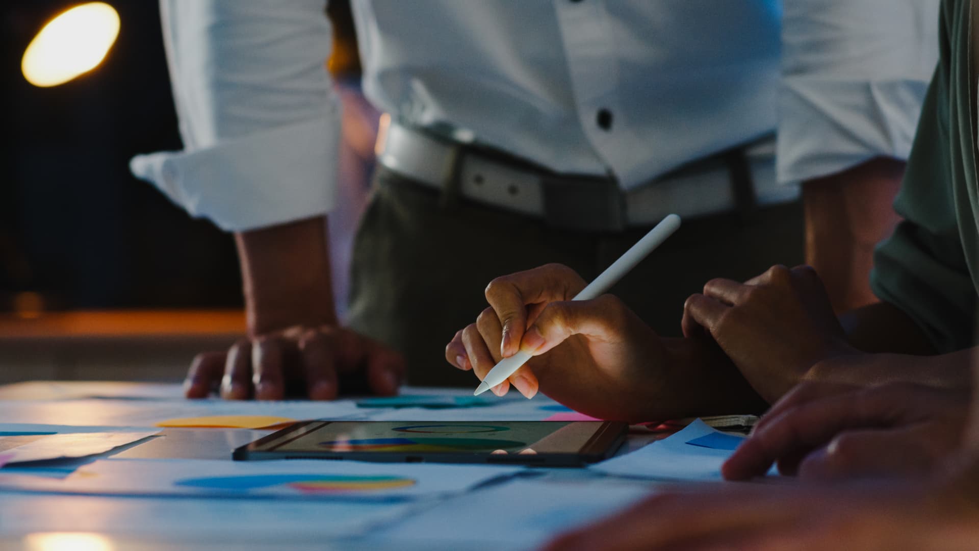 Equipe planejando ações com gráficos e anotações sobre a mesa