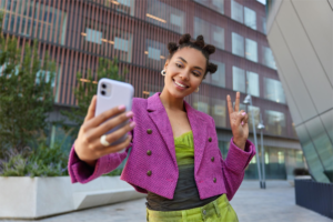 Influenciadora de finanças sorridente fazendo selfie, representando engajamento digital nas redes sociais.